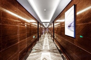 A long, narrow hallway with a reflective floor and walls, leading to a door at the end. - Sibaike Hotel (Zhongshan)