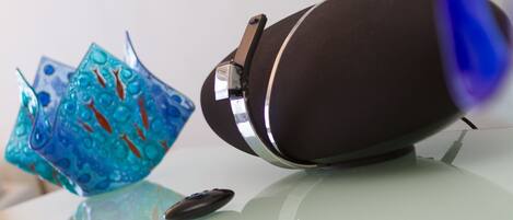 A glass table with a decorative blue glass object and a black object on it.