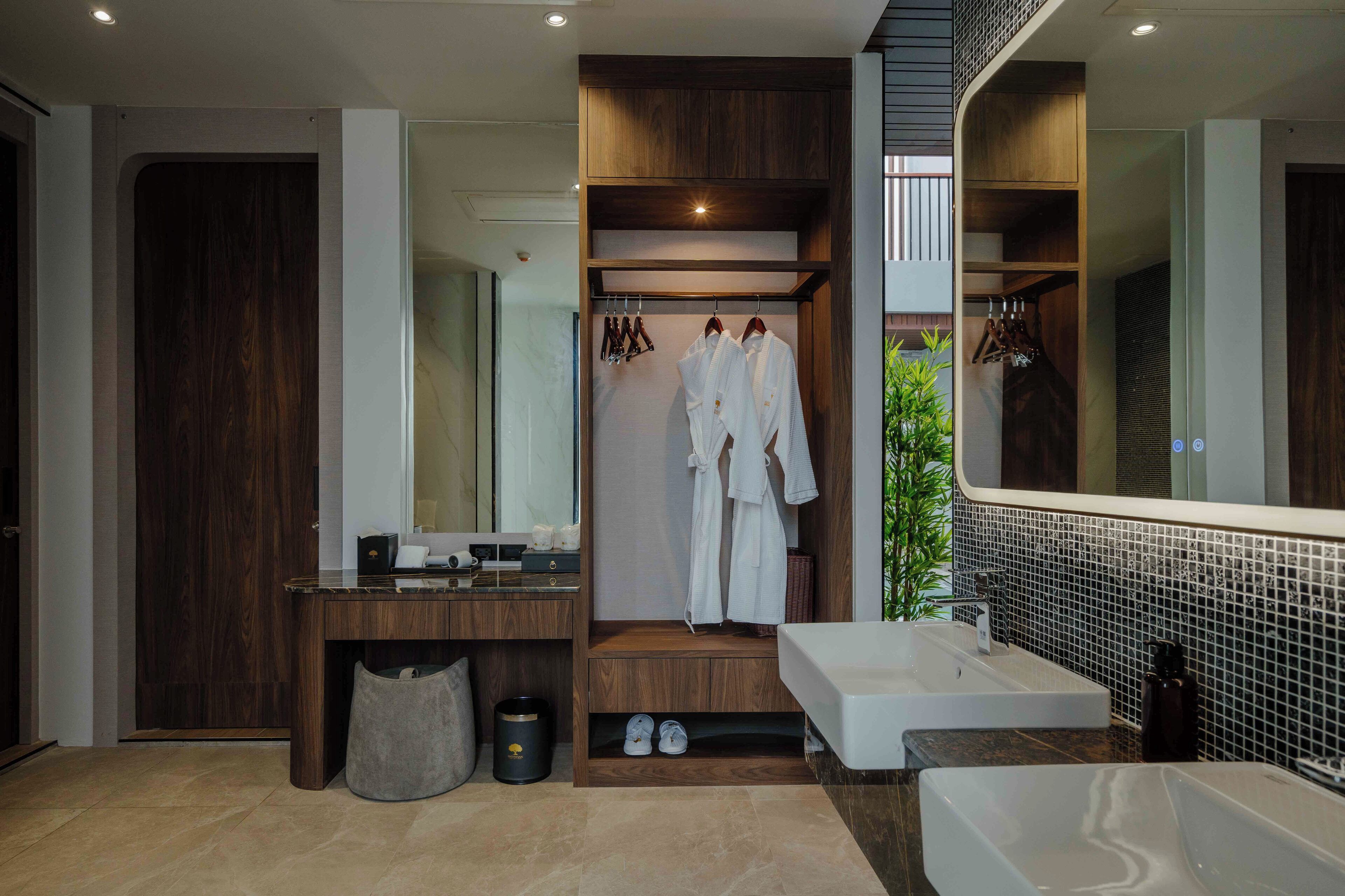 A modern bathroom with a large mirror, wooden vanity, and a walk-in shower.