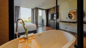 A modern bathroom with a large bathtub, a glass shower enclosure, and a large mirror.