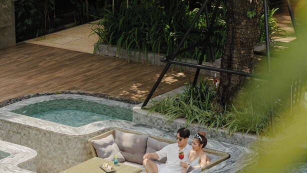 A pool area with multiple seating areas and steps leading into the water. - RICHMANN RESORT HOTEL HATYAI (Hat Yai)