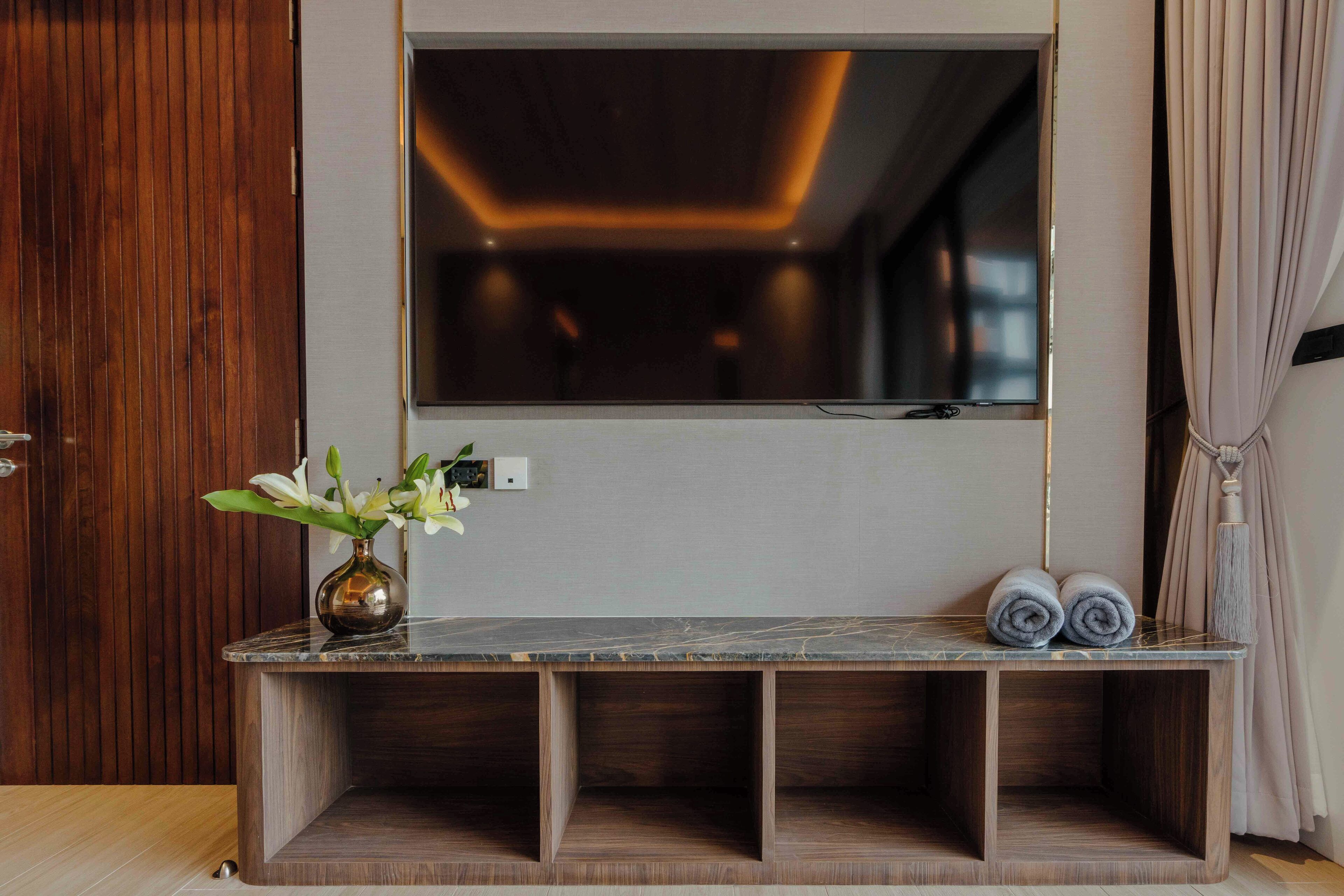 A modern bathroom with a marble vanity, a large mirror, and a wooden cabinet.