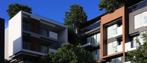 A modern multi-story building with balconies and large windows.
