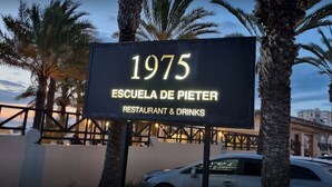 Placa com a inscrição '1975 Escuela de Pieter', com um desenho de restaurante e bebidas.