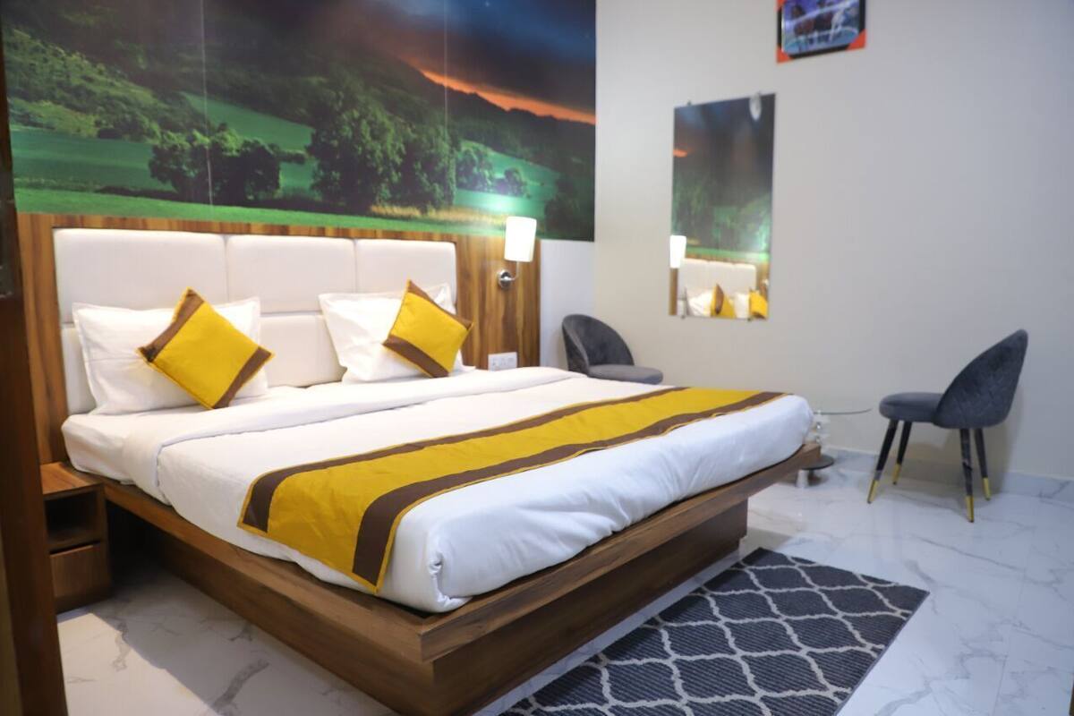 Ein Hotelzimmer mit Bett, Schreibtisch, Stuhl und einer großen Wandmalerei.