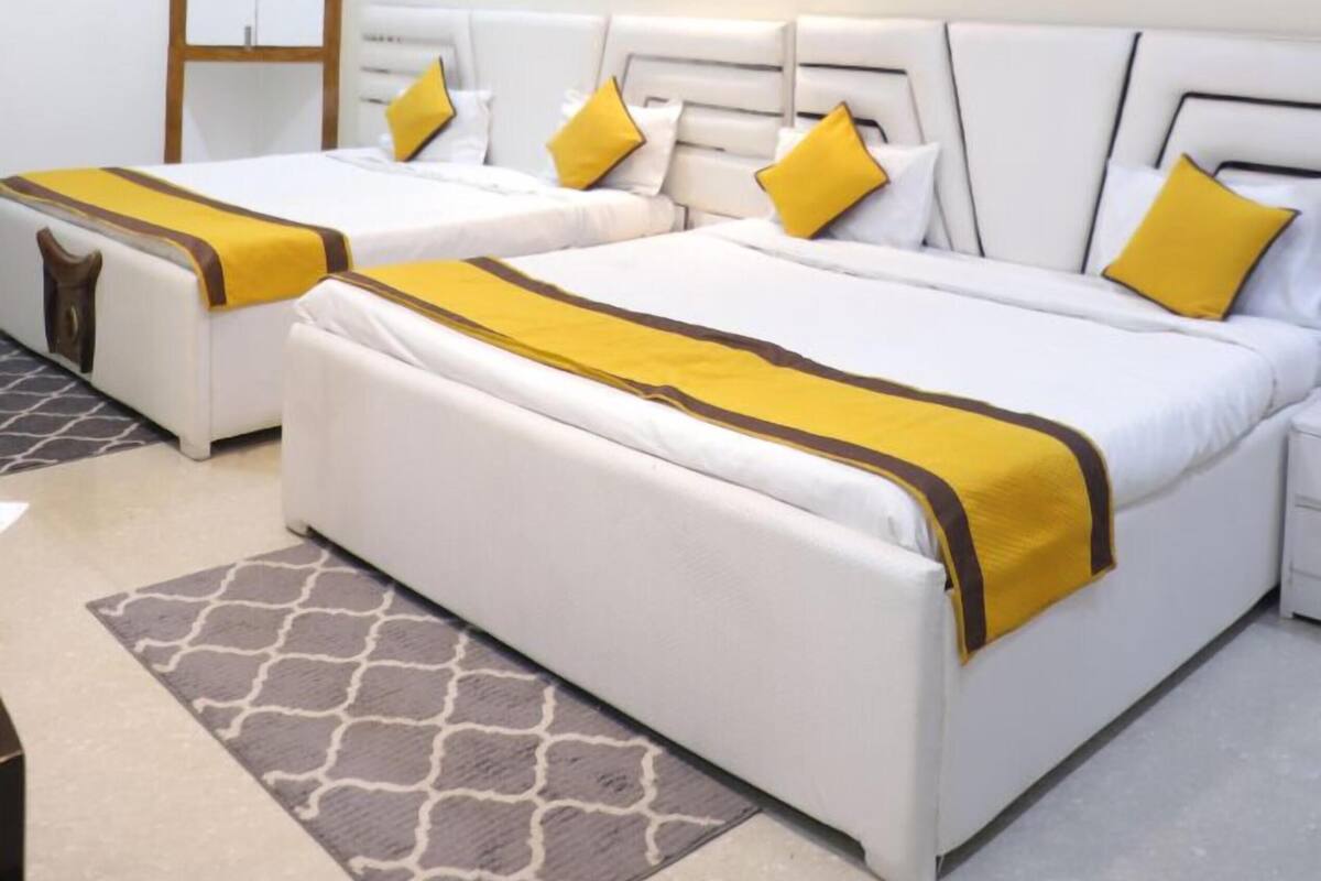 Ein Hotelzimmer mit zwei Betten, einem Deckenventilator, einem Kleiderschrank und zwei Bildern an der Wand.