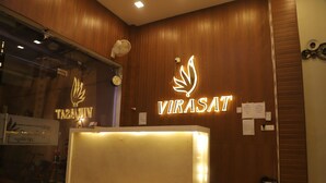 A reception desk with a logo and name 'VIRASAT' illuminated on the wall. - Hotel Virasat Palace By GRB (Mathura)