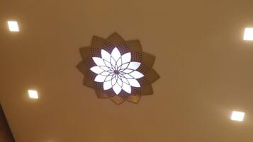 Techo con iluminación empotrada y una lámpara decorativa.