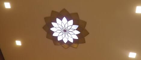 Teto com iluminação embutida e um lustre decorativo.