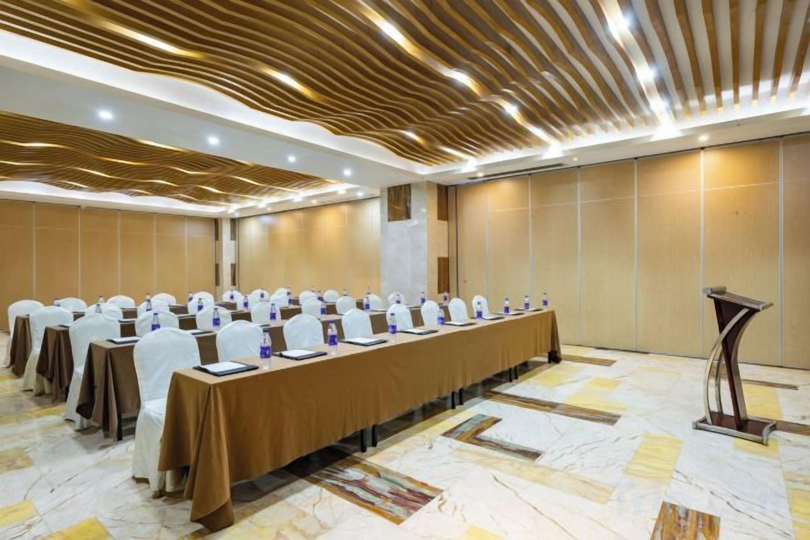 A conference room with a long table, chairs, and a podium.