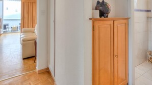Un salón amplio con un mueble de madera y una figurita decorativa de un gato.