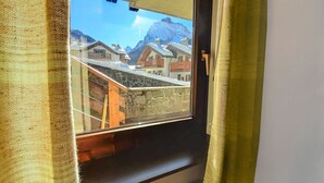 A window with a view of a mountain and buildings. - Nice apartment for 4 guests with TV and pets allowed (Canazei)