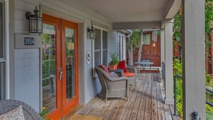 A covered porch with wicker furniture, a wooden table, and a door marked with the number 3954. - Peaceful & Spacious Home with Sauna • Sleeps 12 (Glenwood Springs)