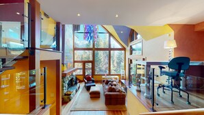 A modern interior with large windows, a fireplace, and a cozy seating area. - Stunning 3 Bedroom / 3.5 Bathroom Blueberry house with breathtaking Mountain Views (Whistler)