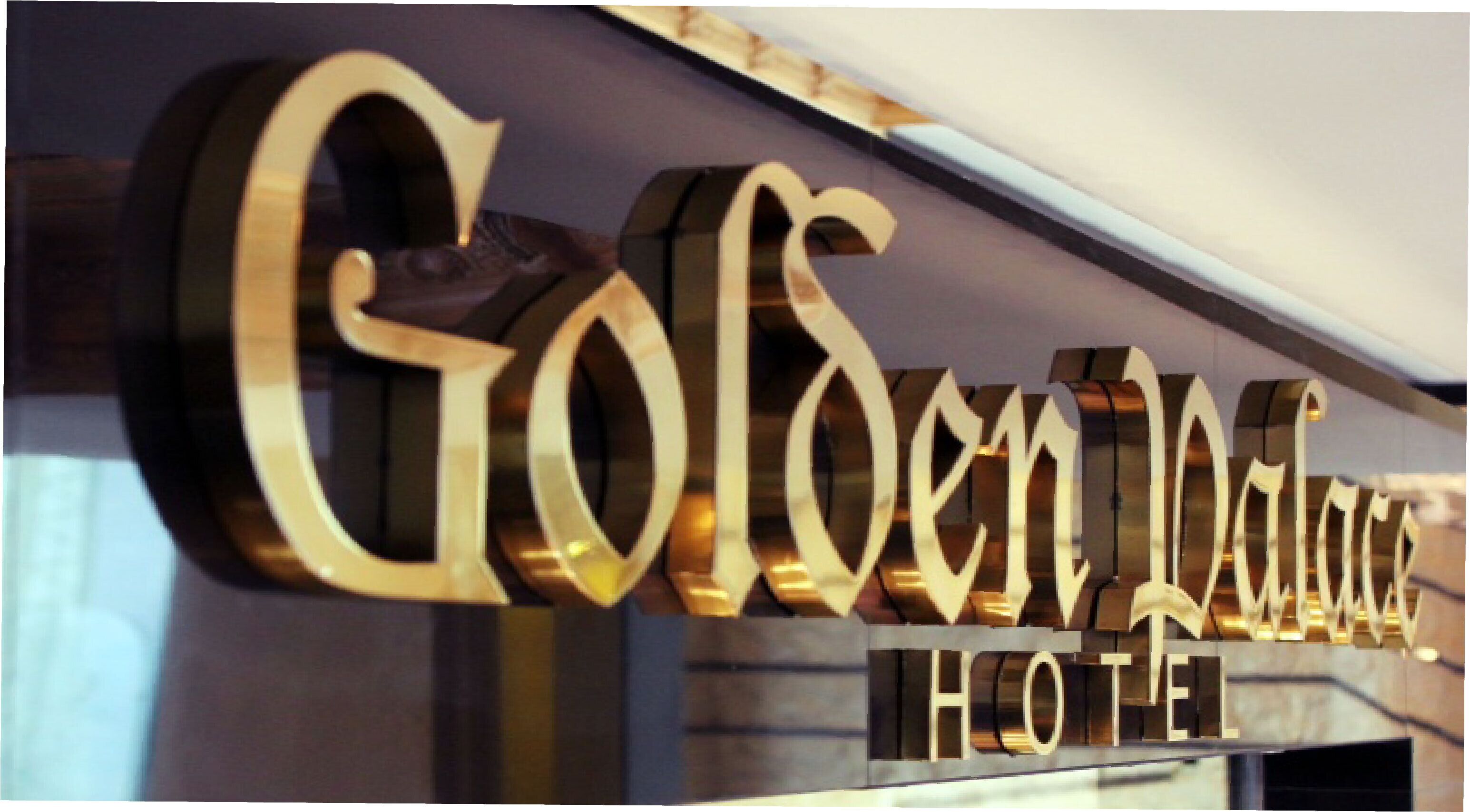 Un letrero de hotel con el nombre 'Glenwood Palace Hotel' en letras grandes y doradas.
