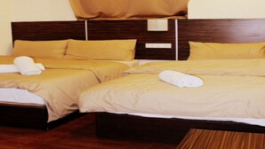 A hotel room with two beds, each with a wooden headboard, beige bedding, and white towels. - GOLDEN PALACE HOTEL (Kuala Lumpur)