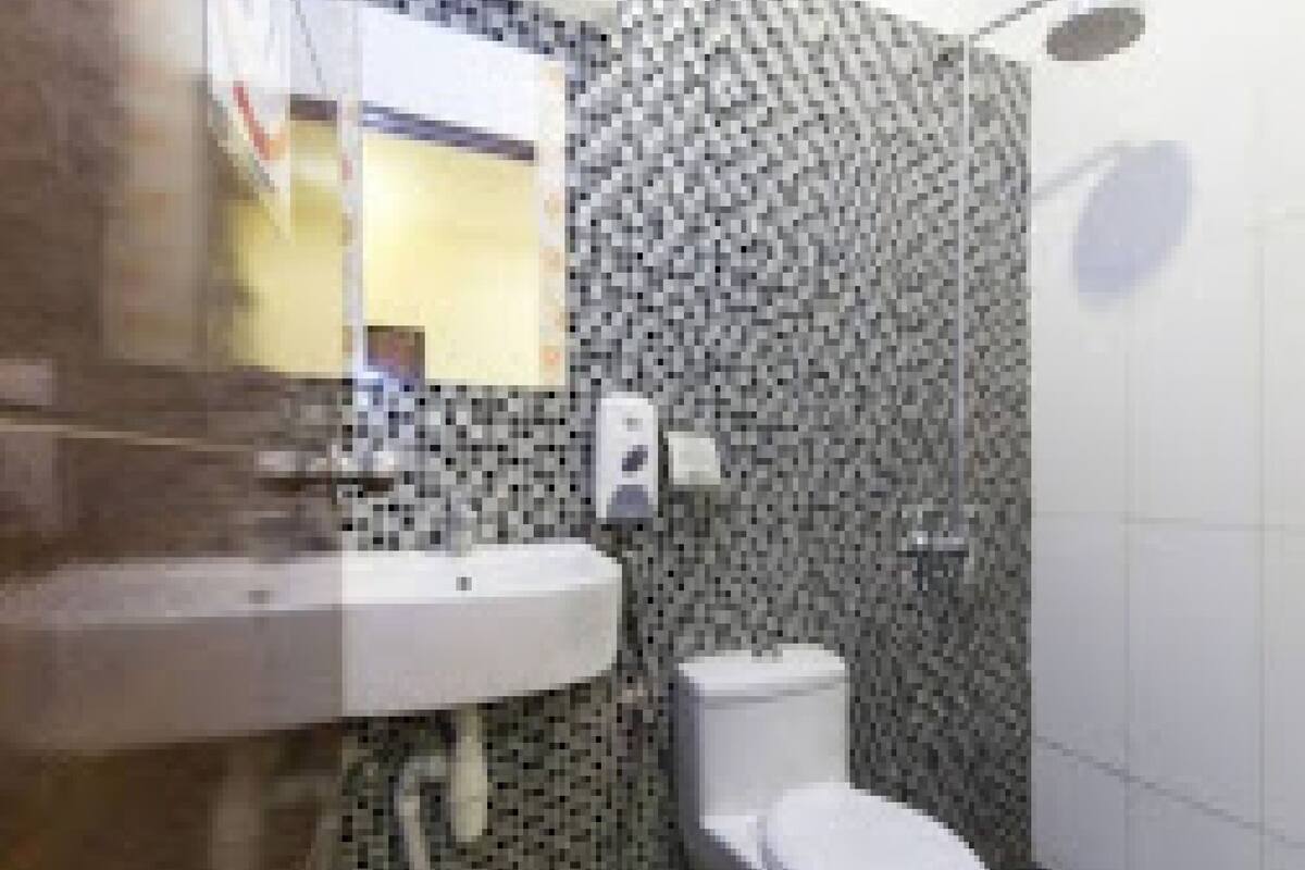 A bathroom with a white sink, a toilet, and a shower area.