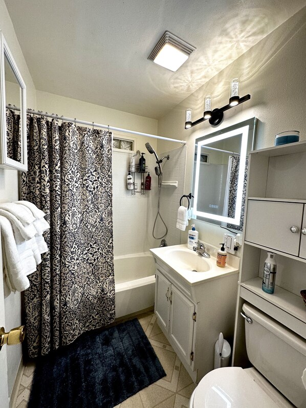 A bathroom with a bathtub, a sink, a toilet, and a shower.