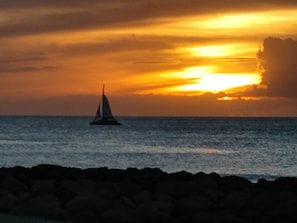 A sailboat on a calm sea during sunset.
