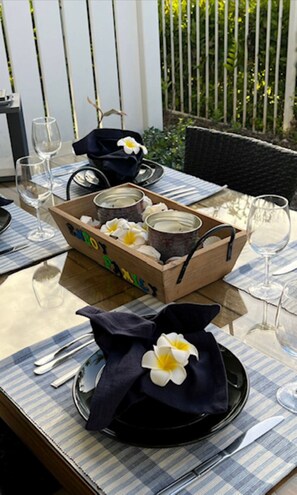 A table set for a meal with a box of candles, a napkin, and a flower.