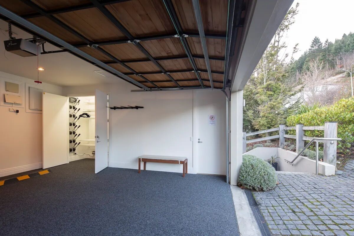 A covered outdoor area with a bench, a wooden ceiling, and a view of a hilly landscape.
