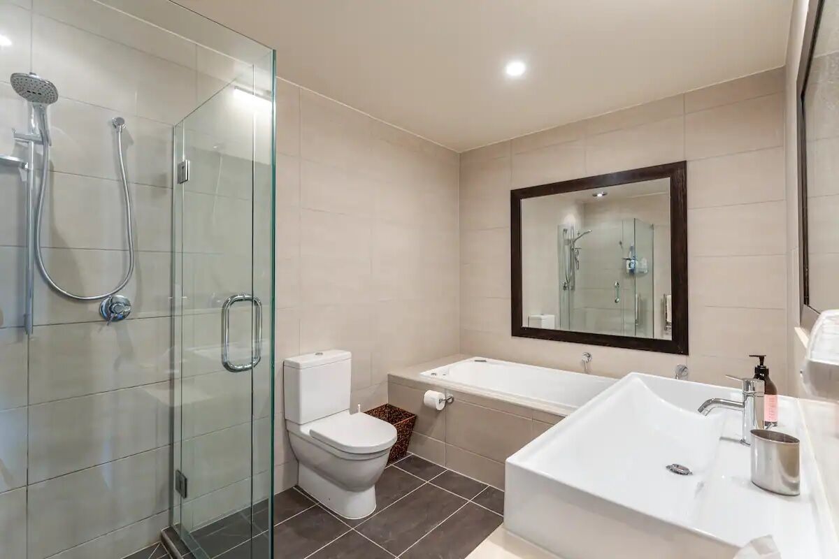 Ein modernes Badezimmer mit Duschkabine, Toilette, Badewanne und großem Waschbecken.