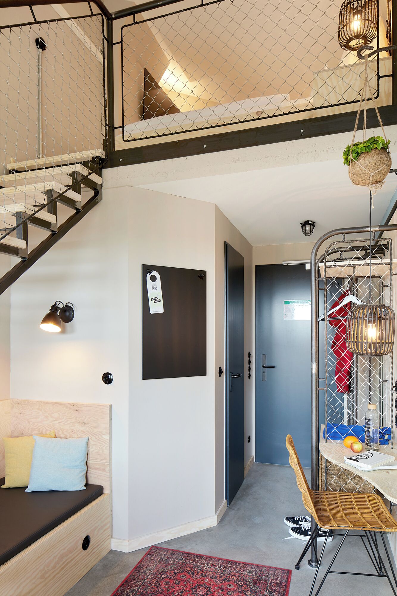 A multi-level apartment with a loft bedroom, a dining area with a table and chairs, and a staircase.