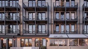 A multi-story hotel with balconies, a pool area, and outdoor seating. - Bretterbude Büsum (Büsum)