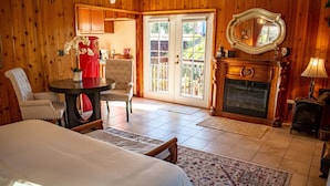 Una habitación acogedora con cama, una mesa de comedor con sillas, una chimenea y un ventanal con vistas al exterior.
