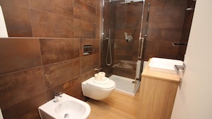 A modern bathroom with a bidet, toilet, and shower. - Boutique Apartment 9 (Lugano)