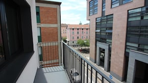 A balcony with a metal railing overlooking a street with buildings. - Boutique Apartment 9 (Lugano)