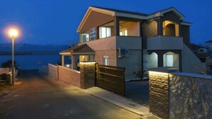 Una casa de dos pisos con balcón, garaje y entrada para vehículos.