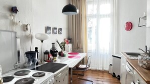 Una cucina compatta con piano cottura, lavello e pavimento in legno.