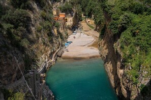 Eine schmale Schlucht mit einem Fluss, Booten und Gebäuden am Flussufer.