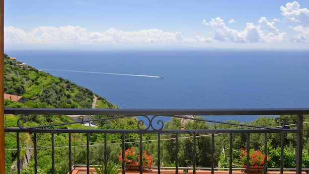 A balcony with a view of the sea and a clear sky.