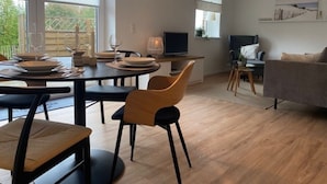 Una sala de estar moderna con comedor, televisor de pantalla plana y sofá.