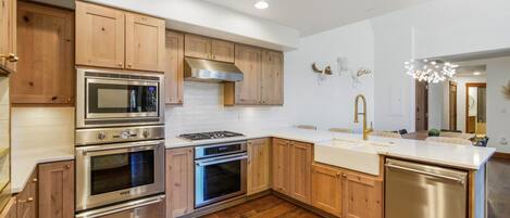 A modern kitchen with wooden cabinets, stainless steel appliances, and a central island.
