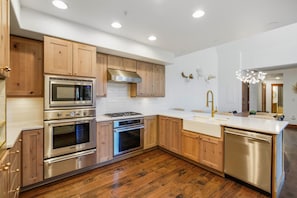A modern kitchen with wooden cabinets, stainless steel appliances, and a central island.