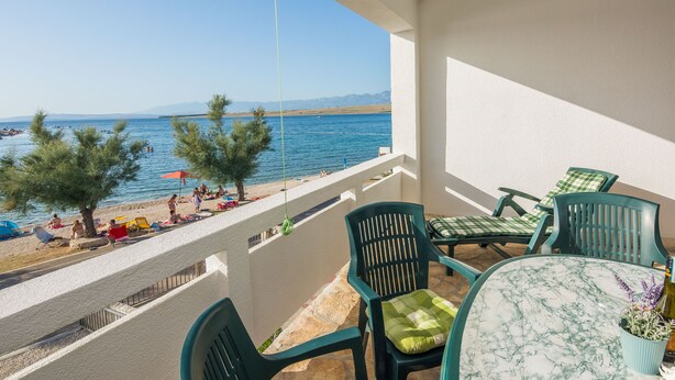 A balcony with a view of the sea, green chairs, a table with a vase, and a red umbrella on the beach. - Apartment Nada (Vir)
