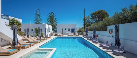 Piscine extérieure en saison, parasols, chaises longues