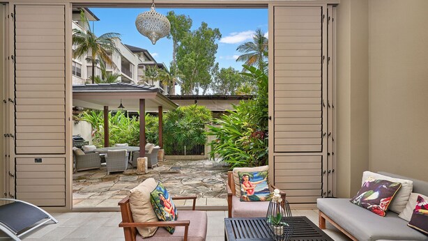 Une terrasse ouverte comprenant un espace repas, des sièges et une vue sur le paysage environnant.