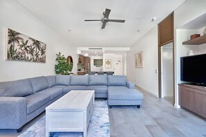 Relax in this stylish living room with a large sofa, coffee table, and flat-screen TV.
