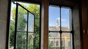 A room with a large window overlooking a historic building with a tower. - Stylish two-bedroom condo with free parking. (London)
