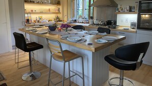 A modern kitchen with a central island, bar stools, and a large window providing natural light. - Stylish two-bedroom condo with free parking. (London)
