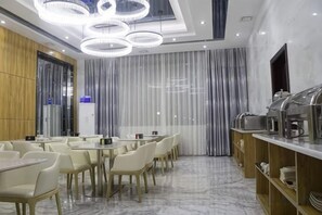 A modern dining area with a long table, chairs, and a buffet counter. - Tianshun Bo'erman Hotel (Zhongshan)