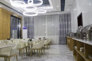 Un comedor moderno con una mesa larga, sillas y un mostrador tipo buffet.