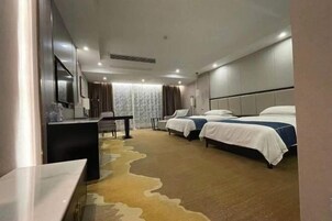 Una habitación de hotel con dos camas, un escritorio y una silla.