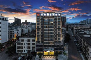 Un hotel de varios pisos con un letrero llamativo en la parte superior, rodeado de otros edificios.