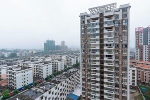 A high-rise residential building with multiple floors, balconies, and a construction crane in the background. - Tianshun Bo'erman Hotel (Zhongshan)