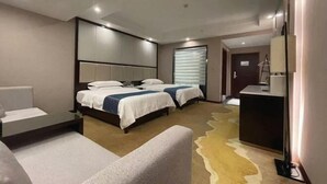 A hotel room with two beds, a desk, a chair, and a large mirror.